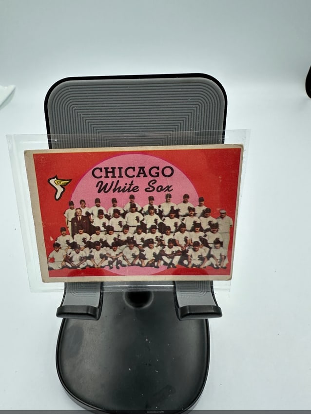 Vintage Chicago White Sox Team Card: A 1959 vintage trading card featuring the chicago white sox, showcasing the team members in a classic pose. The vibrant design includes a striking pink circle background, emphasizing the team's name a