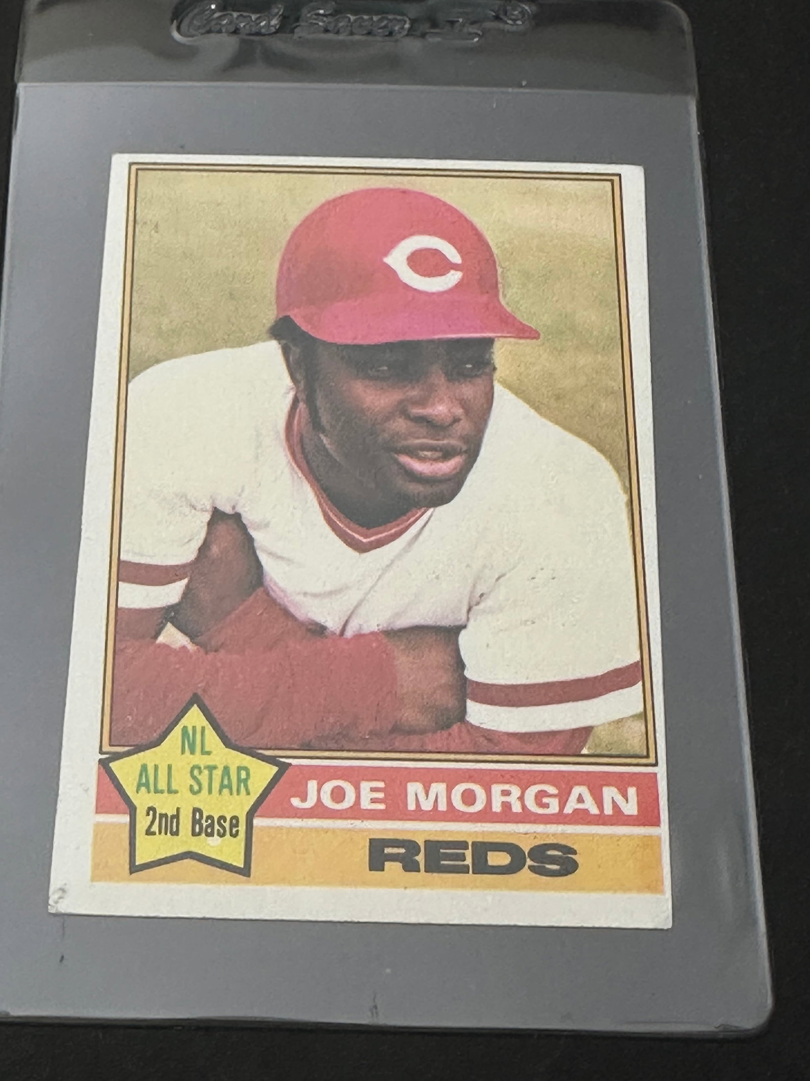 1976 Topps Baseball Card Featuring Hall Of Famer Joe Morgan Of The Cincinnati Reds.: 1976 topps baseball card featuring hall of famer joe morgan. The card shows his statistical career history up to the 1975 season with the cincinnati reds. The item is encased in a protective plastic