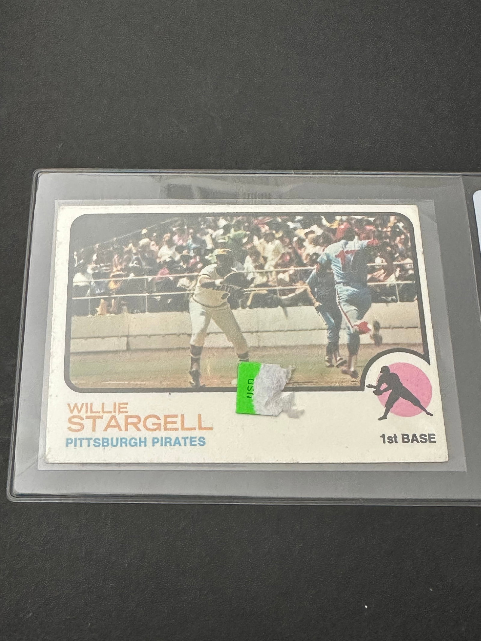 Willie Stargell Of The Pittsburgh Pirates: 1972 topps baseball card featuring willie stargell of the pittsburgh pirates. The card shows signs of age and includes a small remnants of a price sticker on the front surface. It is protected within