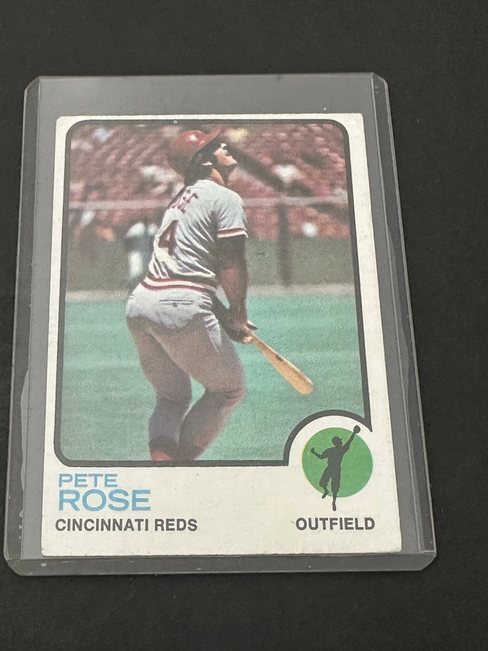 Pete Rose In An Outfield Position: 1972 topps baseball card featuring cincinnati reds player pete rose in an outfield position. The card is encased in a protective plastic top loader. It shows classic 1972 era design with a circular