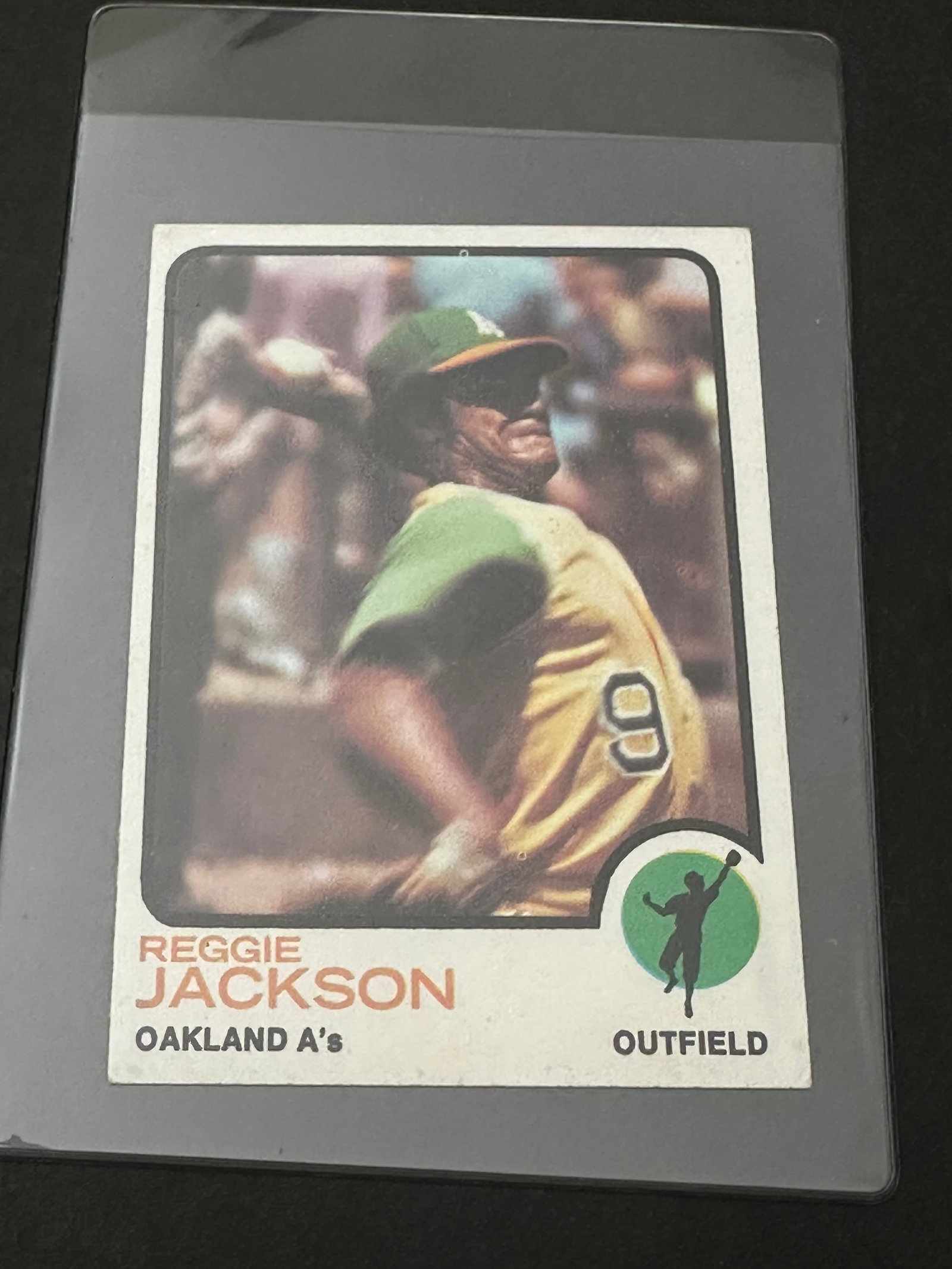 Reggie Jackson Of The Oakland Athletics: 1973 topps baseball card featuring reggie jackson, card number 255. It highlights his batting record from 1966 to 1972 and includes a blurb about his 1972 playoff performance. The card is enclosed in