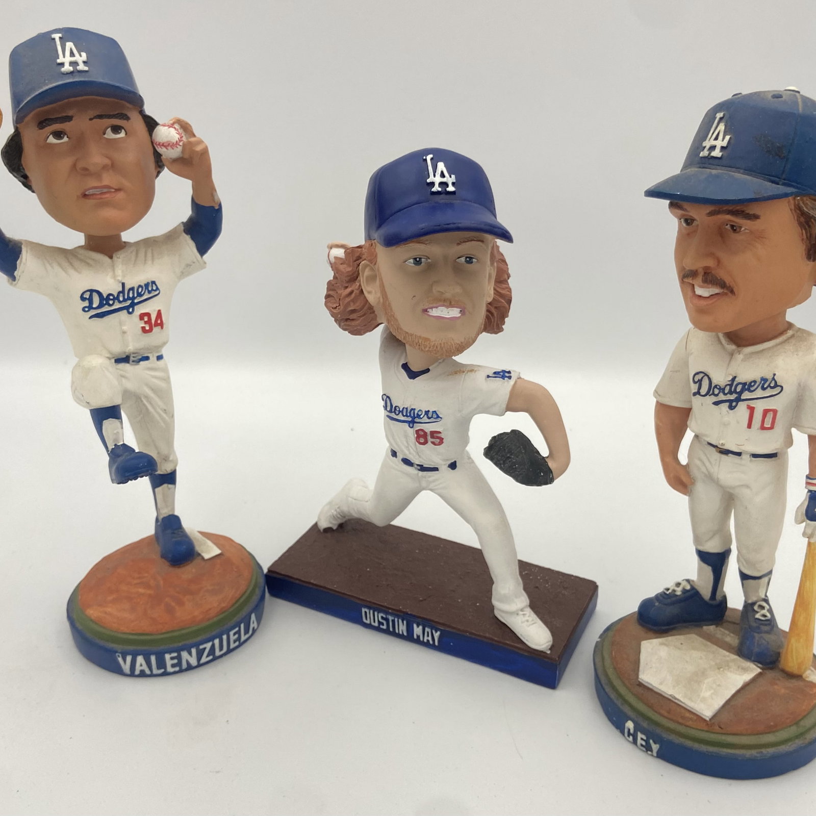 Los Angeles Dodgers Bobblehead Set: This set features three Los Angeles Dodgers player bobbleheads: Fernando Valenzuela, Dustin May, and Ron Cey. Each figure captures the player in a dynamic baseball pose wearing their classic Dodgers