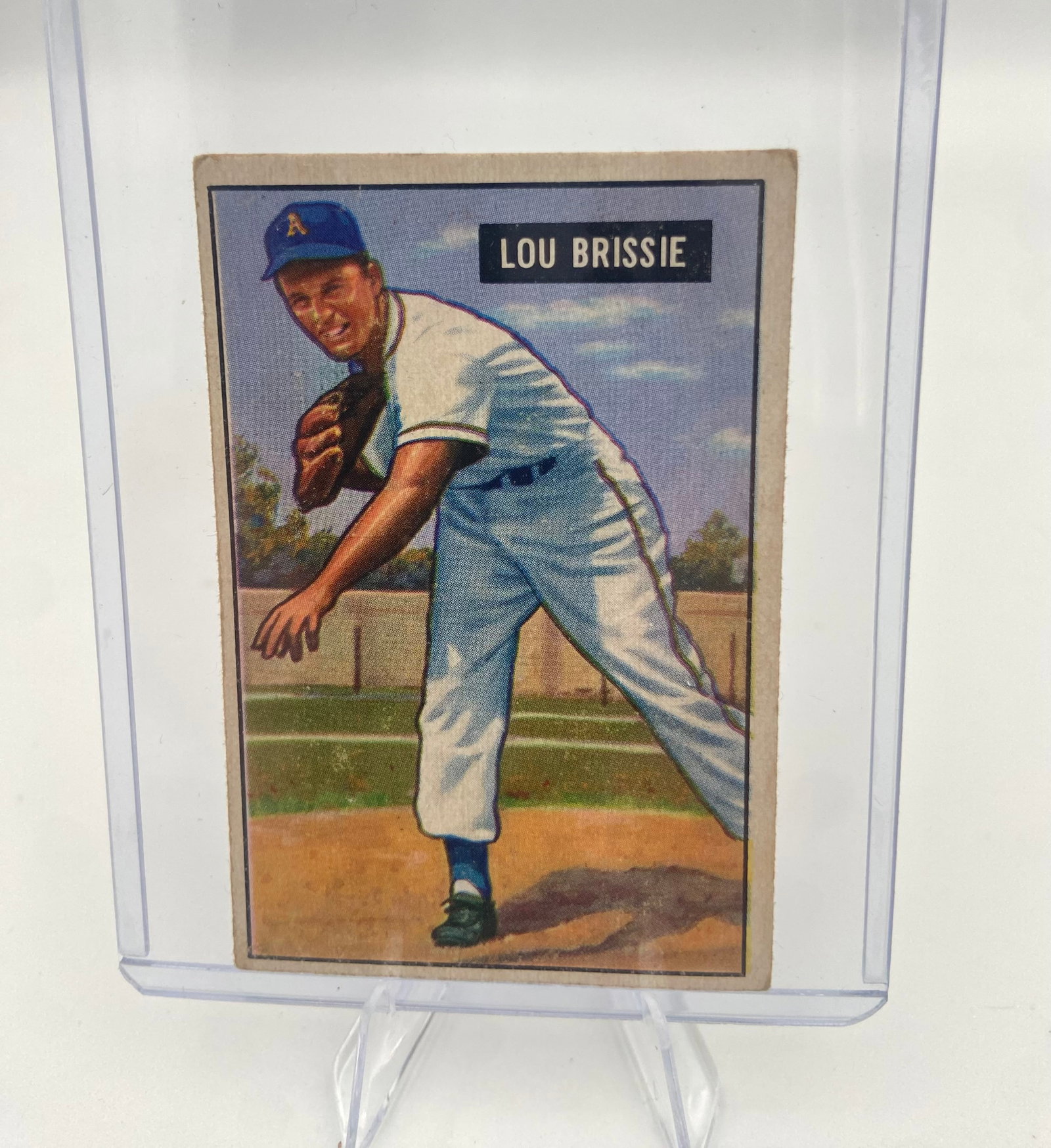 1949 Bowman Lou Brissie Baseball Card: This is a 1949 Bowman baseball card featuring Philadelphia Athletics pitcher Lou Brissie. The card shows a colorized illustration of Brissie in his pitching delivery. It is presented in a hard