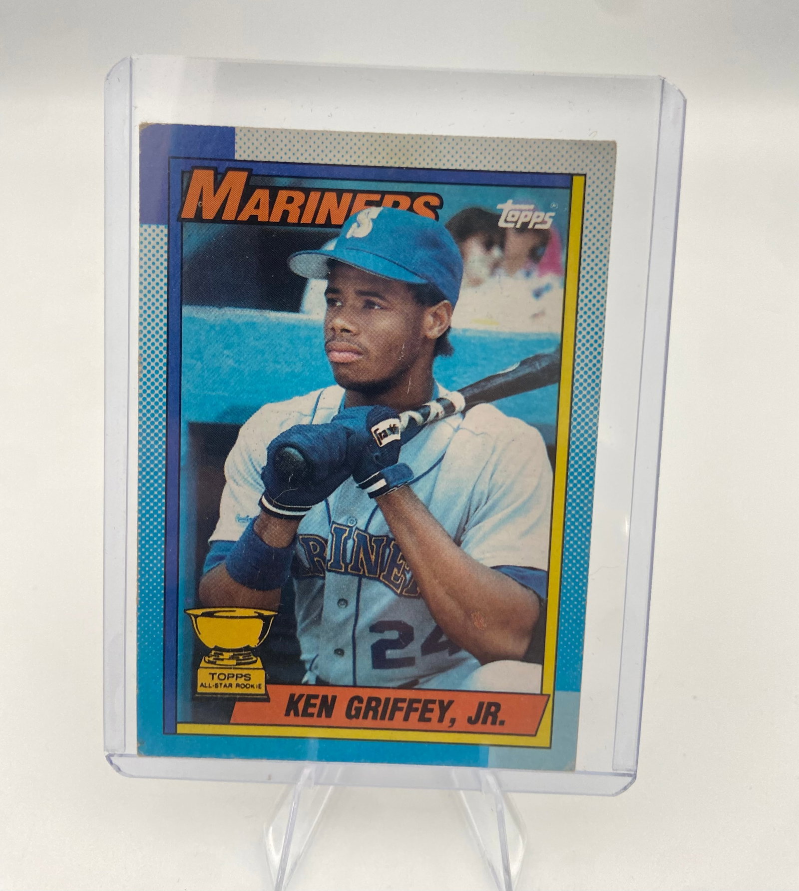 1989 Topps Ken Griffey Jr. Rookie Card: This is the iconic 1989 Topps baseball card featuring Hall of Famer Ken Griffey Jr. in his Seattle Mariners uniform. It includes the Topps All-Star Rookie trophy emblem, widely considered one of the m