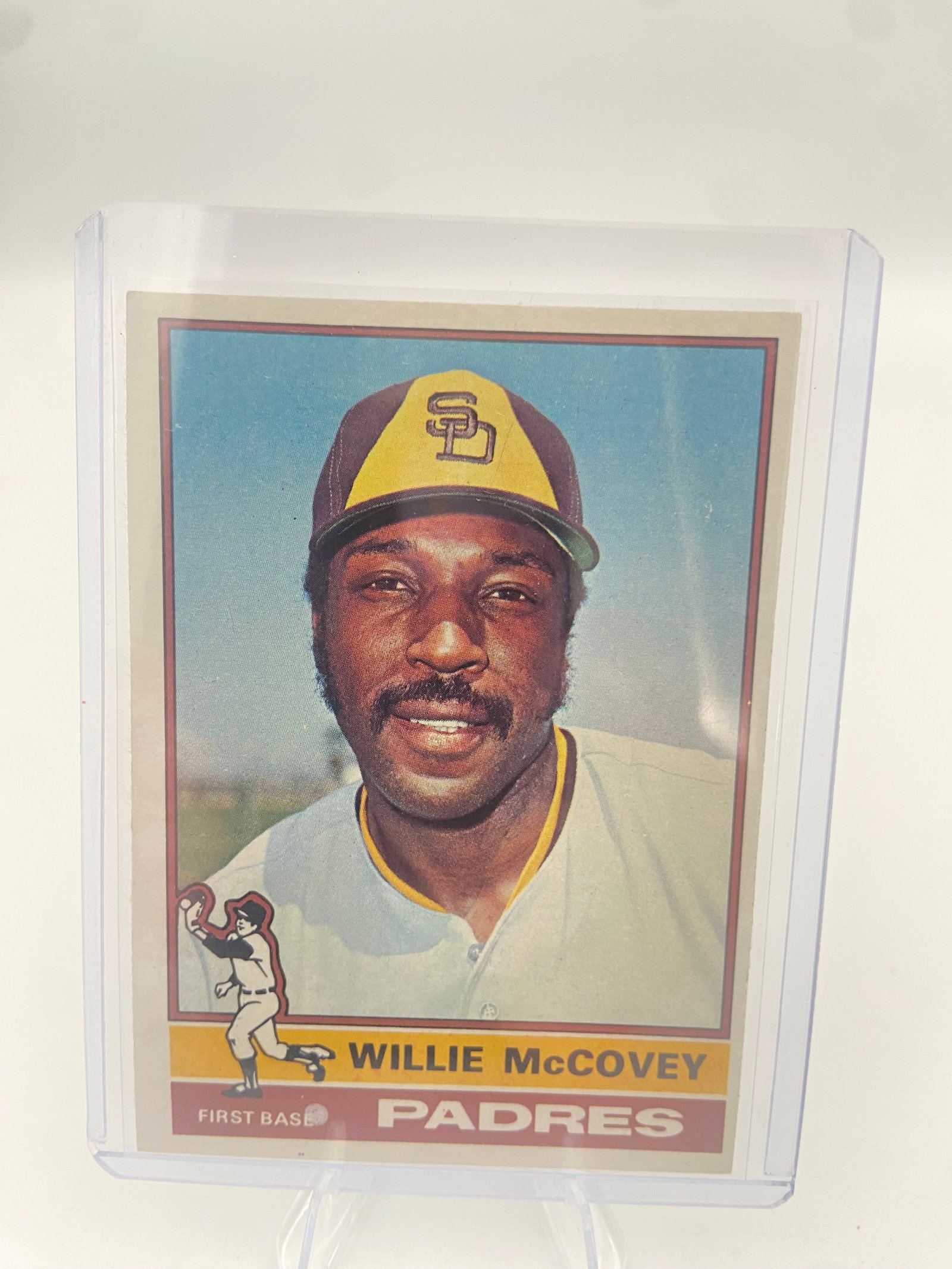 1975 Topps Willie McCovey: This is a 1975 Topps baseball card featuring Willie McCovey of the San Diego Padres. It is a portrait-style card from the mid-1970s era and is encased in a protective plastic top loader.