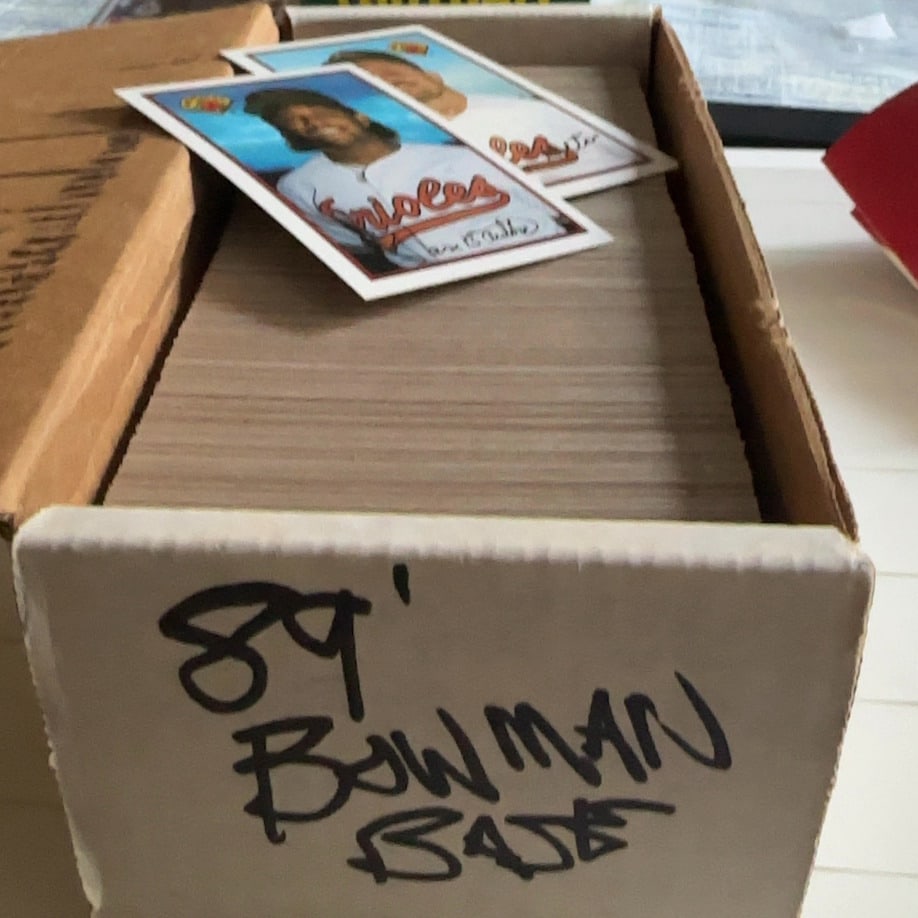 Small Sets - Sports Trading Cards: 1989 Bowman baseball trading cards. The box is hand-labeled with '89 Bowman Base' on the front exterior. A 1989 Bowman Randy Milligan card is resting on top of the stack inside the container.Unsorted