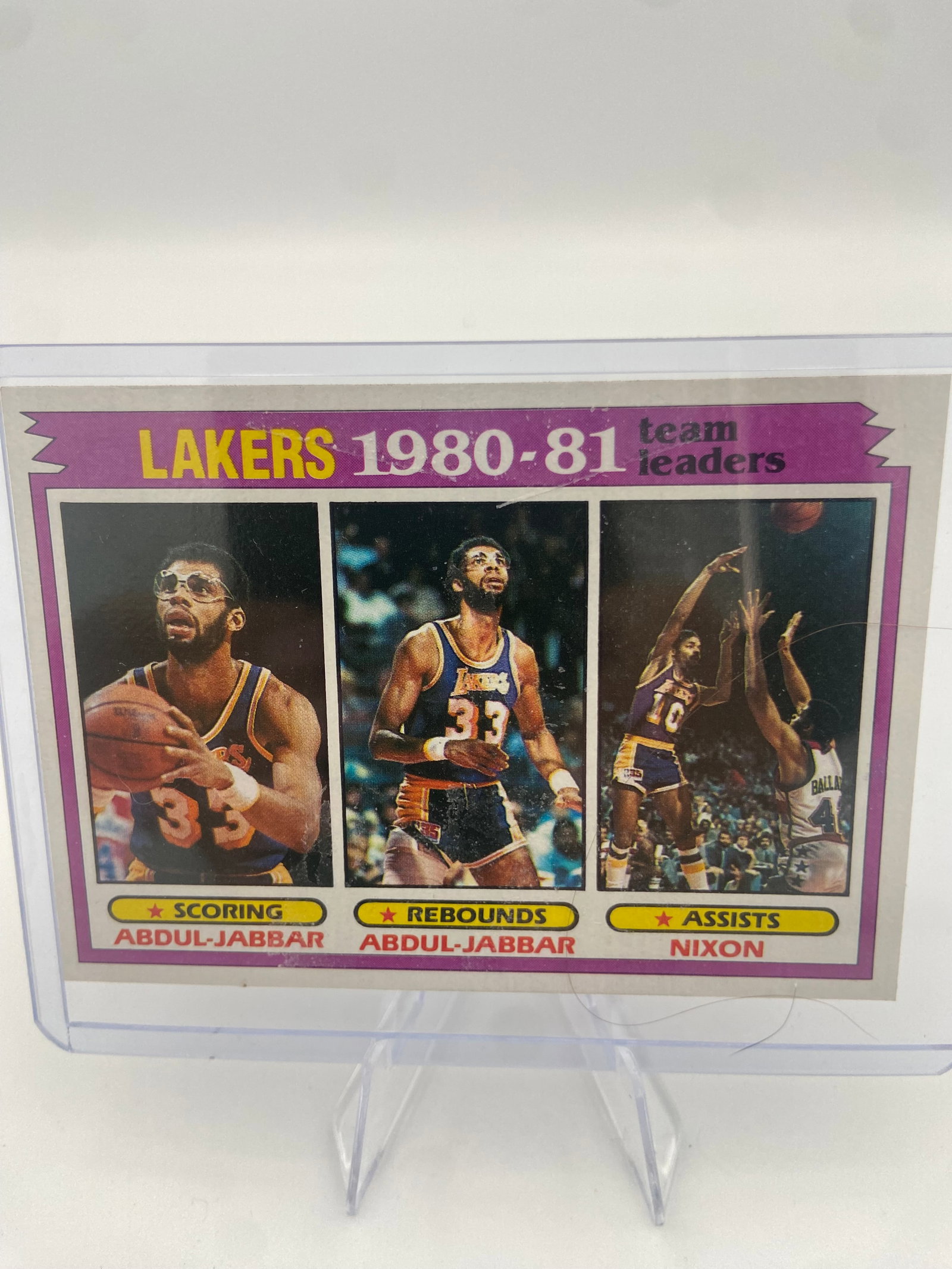 1981-82 Topps Los Angeles Lakers Team Leaders Card: This is a 1981-82 Topps basketball card featuring Los Angeles Lakers team leaders. The card highlights Kareem Abdul-Jabbar for scoring and rebounding, and Norm Nixon for assists. The card is encased