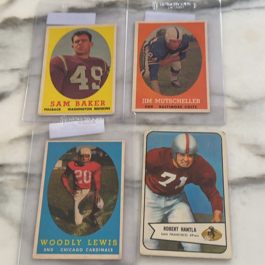Vintage Football Trading Card Lot: This lot includes four vintage football trading cards featuring players Sam Baker, Jim Mutscheller, Woodly Lewis, and Robert Hantla. The cards are preserved in plastic sleeves and display team