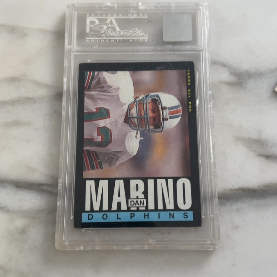 1990 Topps Dan Marino #323: This is a graded 1990 Topps Dan Marino football card (#323) featuring the 'Topps All Pro' designation and 'Dolphins' team name. The card is encapsulated in a protective PSA slab.