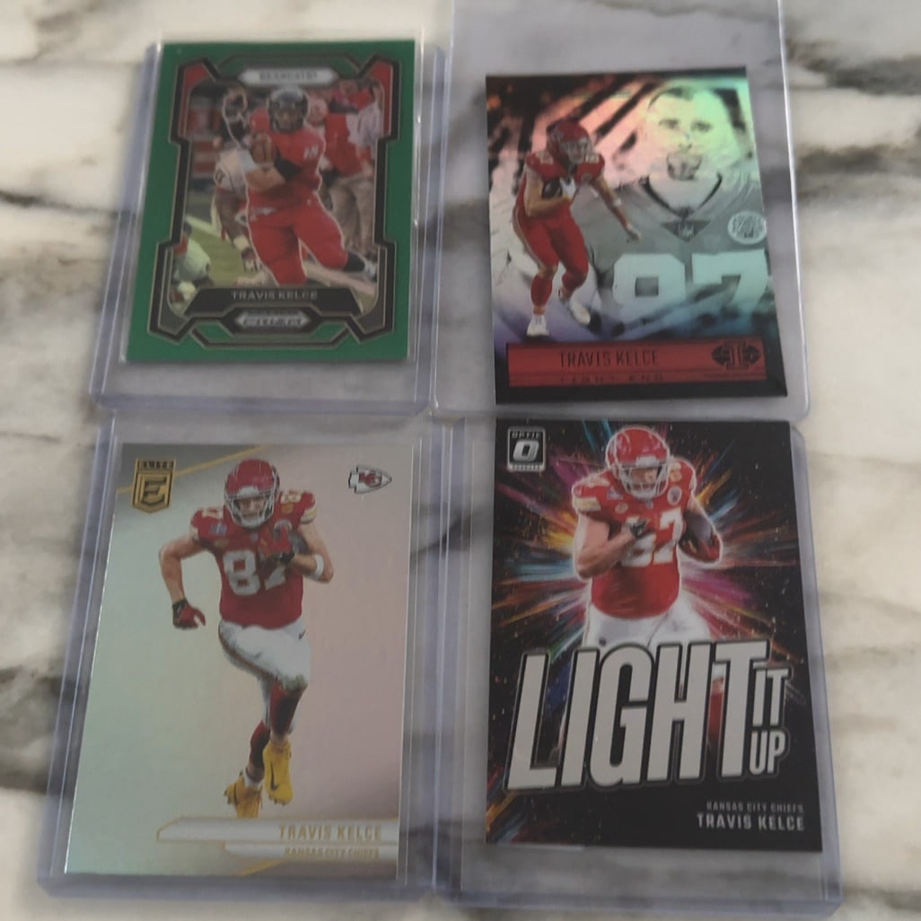 Travis Kelce Football Cards Lot: This lot features four different football trading cards of Travis Kelce. The collection includes a Panini Prizm Draft Picks card showing him with the Cincinnati Bearcats, along with Panini Illusions,