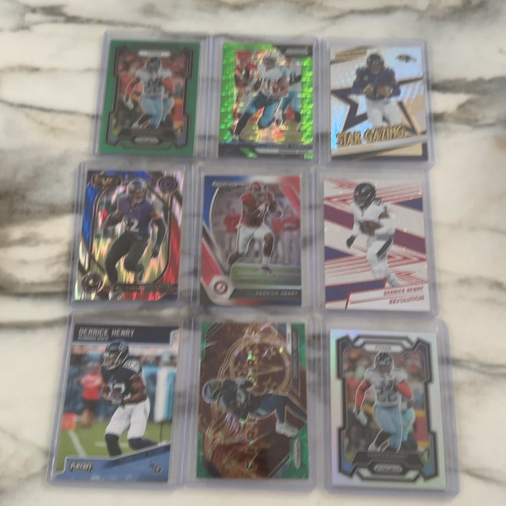 Derrick Henry Trading Card Collection: This image features an assortment of nine individual Derrick Henry football trading cards stored in protective hard plastic cases. The collection includes various Panini brand designs such as Prizm,