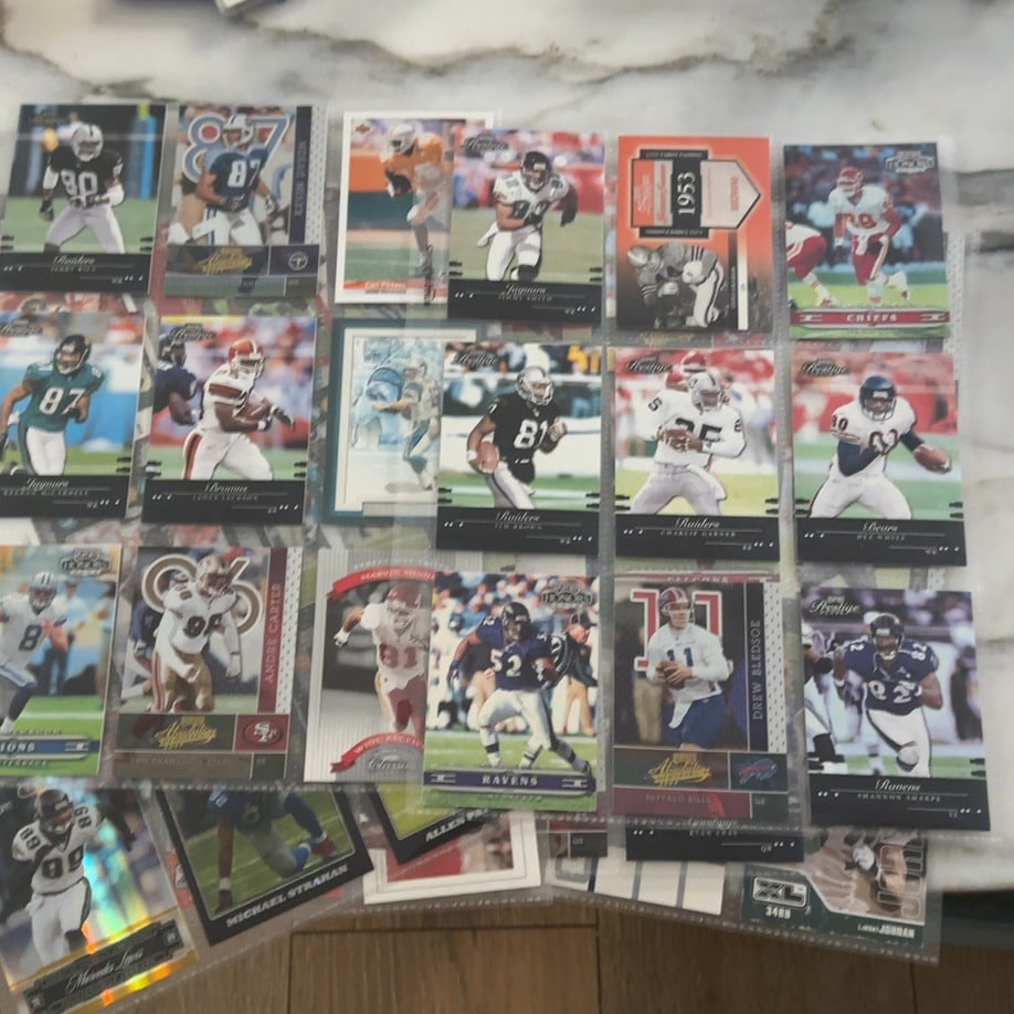 Assorted 2001 NFL Trading Cards Collection: This is a collection of various NFL trading cards from 2001 housed in a plastic binder sheet. The collection features players from teams such as the Raiders, Ravens, Bills, and Chiefs, including
