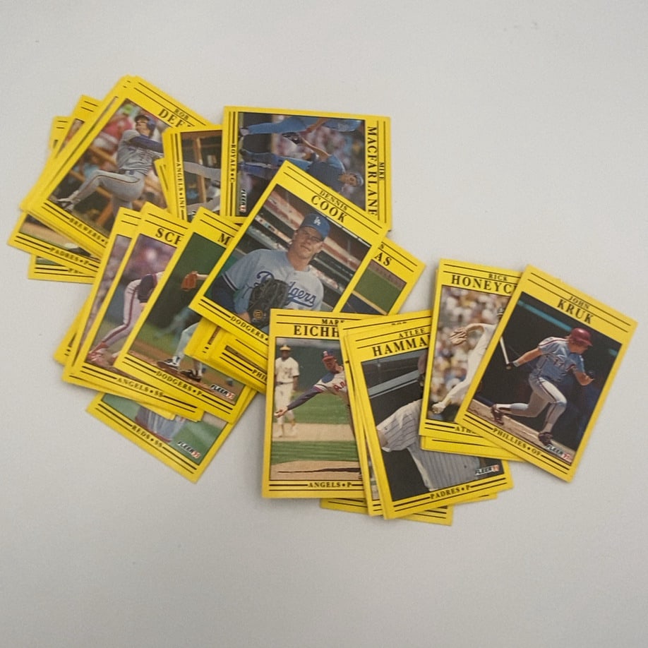 1991 Fleer Baseball Card Lot: A unsorted collection of 1991 Fleer baseball cards featuring various players, identifiable by their signature yellow borders and the 'FLEER 91' logo printed on the front of each card.Raw - ungraded -