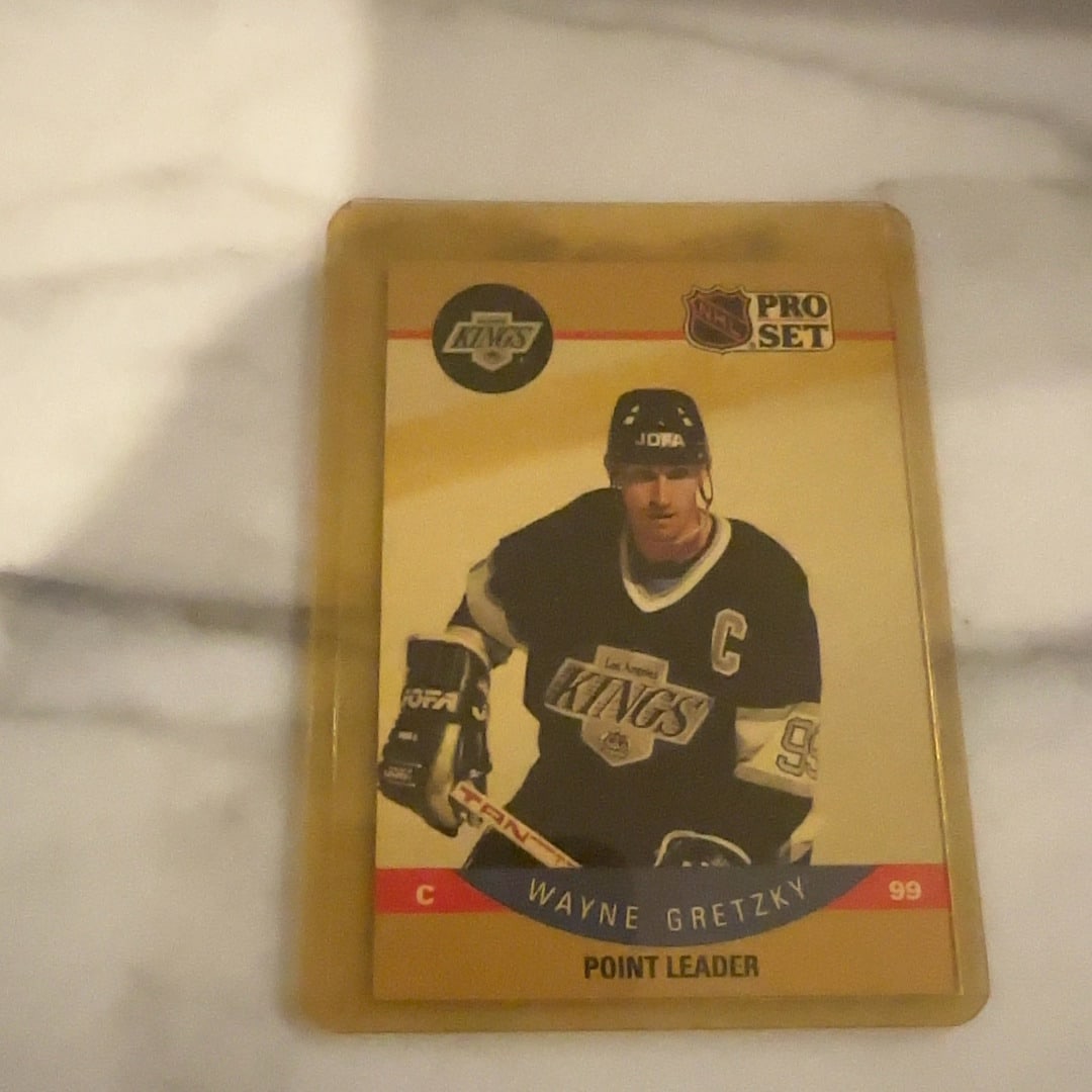 1990 Pro Set Wayne Gretzky Point Leader Hockey Card: This is a 1990 Pro Set hockey trading card featuring the legendary Wayne Gretzky in his Los Angeles Kings uniform. The card identifies him as a point leader and showcases the iconic Pro Set design of