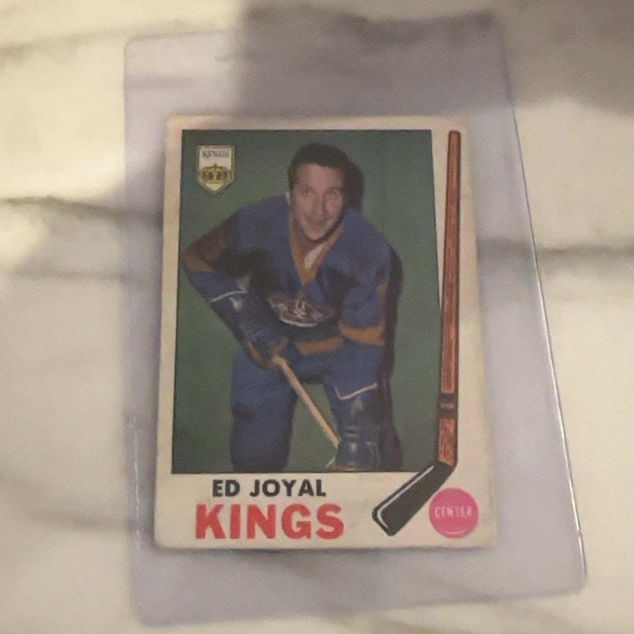 1968-69 O-Pee-Chee Ed Joyal Hockey Card: This is a 1968-69 O-Pee-Chee hockey card featuring Ed Joyal of the Los Angeles Kings. The card displays a portrait of the player with the team logo and a hockey stick graphic on the front.