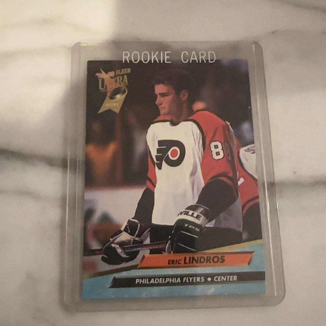 1992-93 Fleer Ultra Eric Lindros Rookie Card: This is a 1992-93 Fleer Ultra rookie hockey card featuring Eric Lindros of the Philadelphia Flyers. It is encased in a protective top loader and serves as a classic collectible from the early 1990s