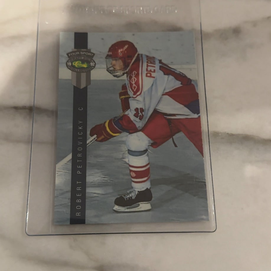 1992 Classic Four Sport Robert Petrovicky Rookie Card: This is a 1992 Classic Four Sport hockey trading card featuring Robert Petrovicky in his draft year. The card showcases the player in his ice hockey uniform and is preserved in a protective plastic sl