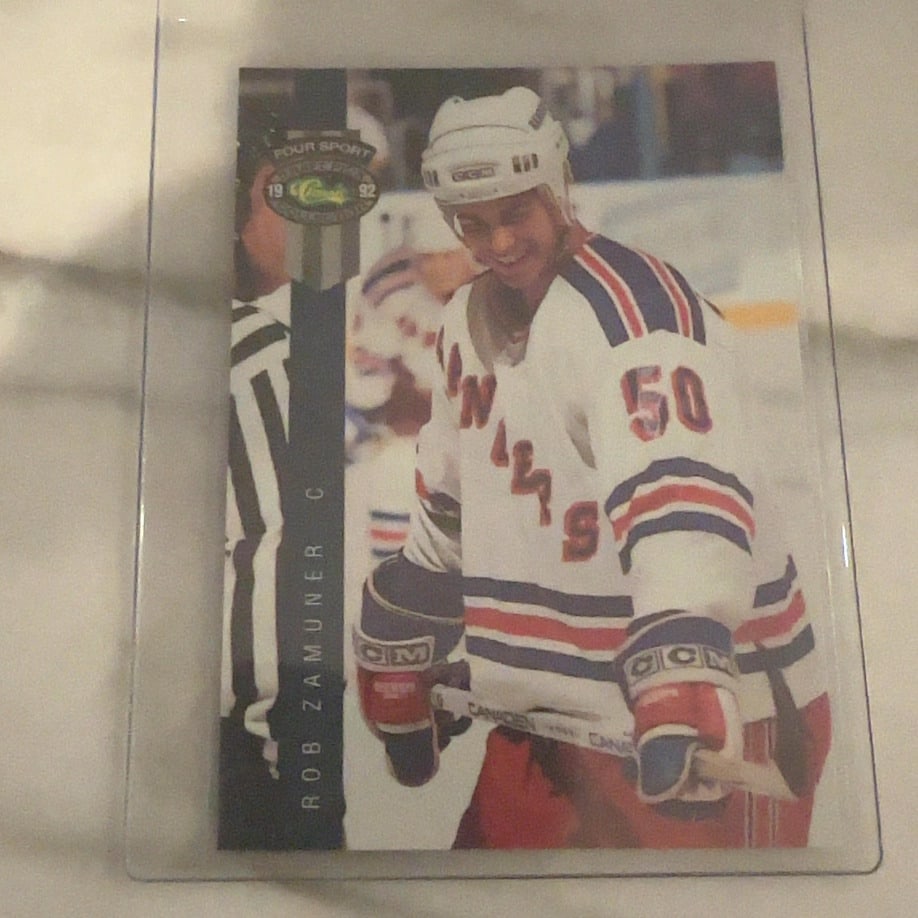 Rob Zamuner 1992 Classic Four Sport Hockey Card: This is a 1992 Classic Four Sport trading card featuring NHL player Rob Zamuner. The card showcases him in his New York Rangers uniform and is part of a multi-sport set produced by Classic. The card i