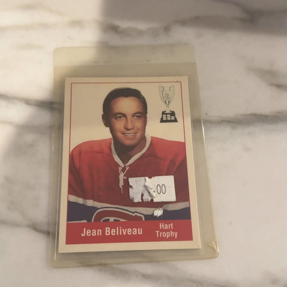 Jean Beliveau Hart Trophy Trading Card: This is a vintage 1960s era hockey trading card featuring Montreal Canadiens legend Jean Beliveau. The card commemorates his Hart Trophy win and is encased in a protective plastic sleeve, though it sh