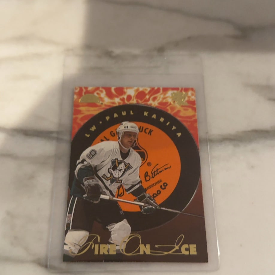 Paul Kariya 1996-97 Pinnacle Fire On Ice Hockey Card: This is a 1996-97 Pinnacle Fire on Ice hockey trading card featuring Anaheim Ducks star Paul Kariya. The card showcases a distinct flame-themed background and a facsimile autograph, highlighting