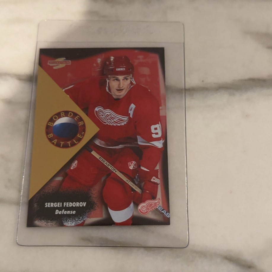 Sergei Fedorov 1997-98 Pinnacle Border Battle Card: This is a 1997-98 Pinnacle Border Battle insert trading card featuring NHL legend Sergei Fedorov of the Detroit Red Wings. The card showcases a distinct gold-accented design and is preserved in a
