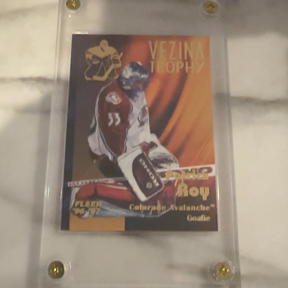 Patrick Roy 1996-97 Fleer Vezina Trophy Insert: This is a 1996-97 Fleer hockey trading card featuring goaltender Patrick Roy of the Colorado Avalanche. It is a special Vezina Trophy insert card from the mid-90s, presented in a clear protective