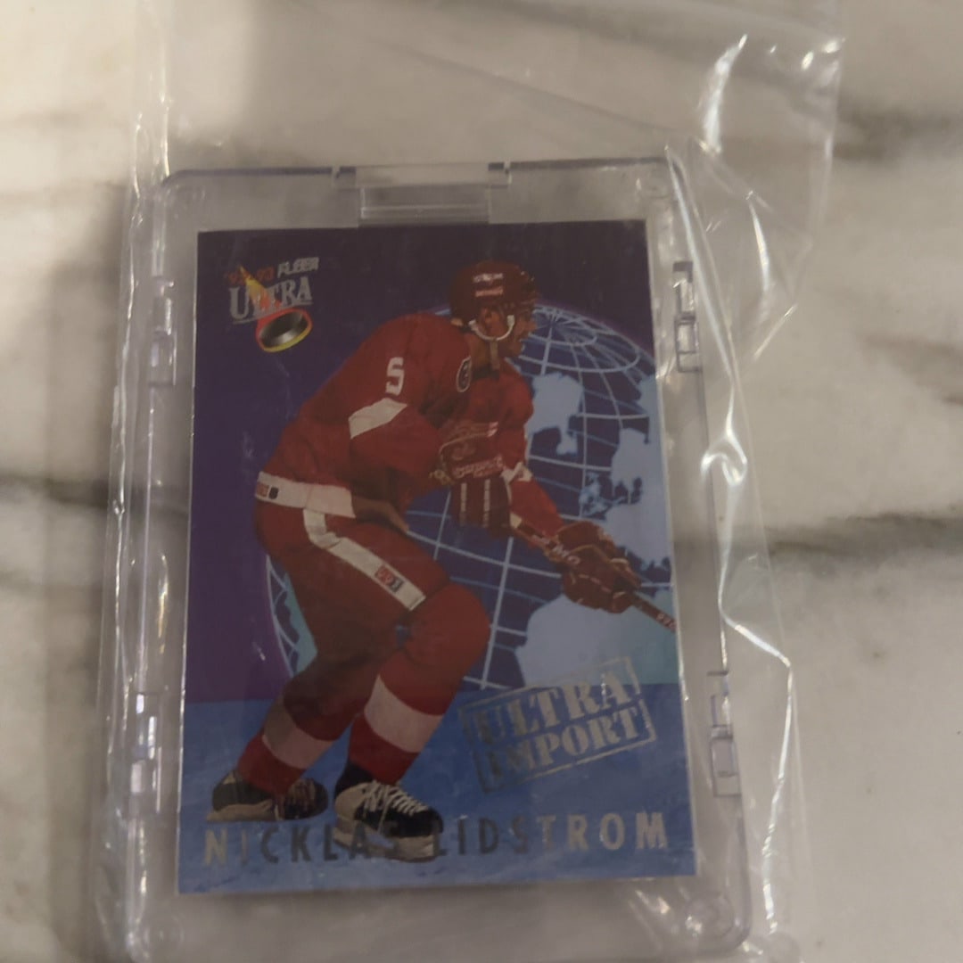 1992-93 Fleer Ultra Nicklas Lidstrom Import: This is a 1992-93 Fleer Ultra hockey card featuring Nicklas Lidstrom of the Detroit Red Wings. The card is the Ultra Import subset and is stored in a protective plastic hard case inside a plastic