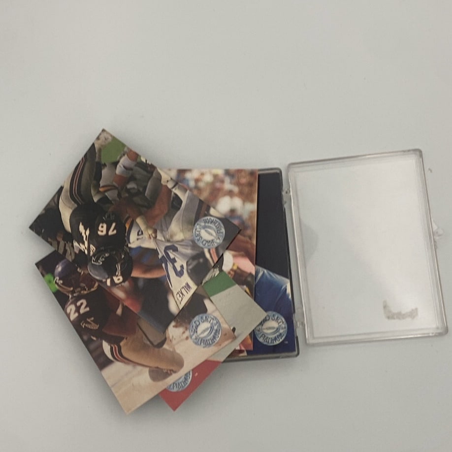 1991 Pro Set Platinum Football Cards: A collection of 1991 Pro Set Platinum football trading cards featuring action shots of NFL players, including Herschel Walker, shown with a clear plastic storage case.