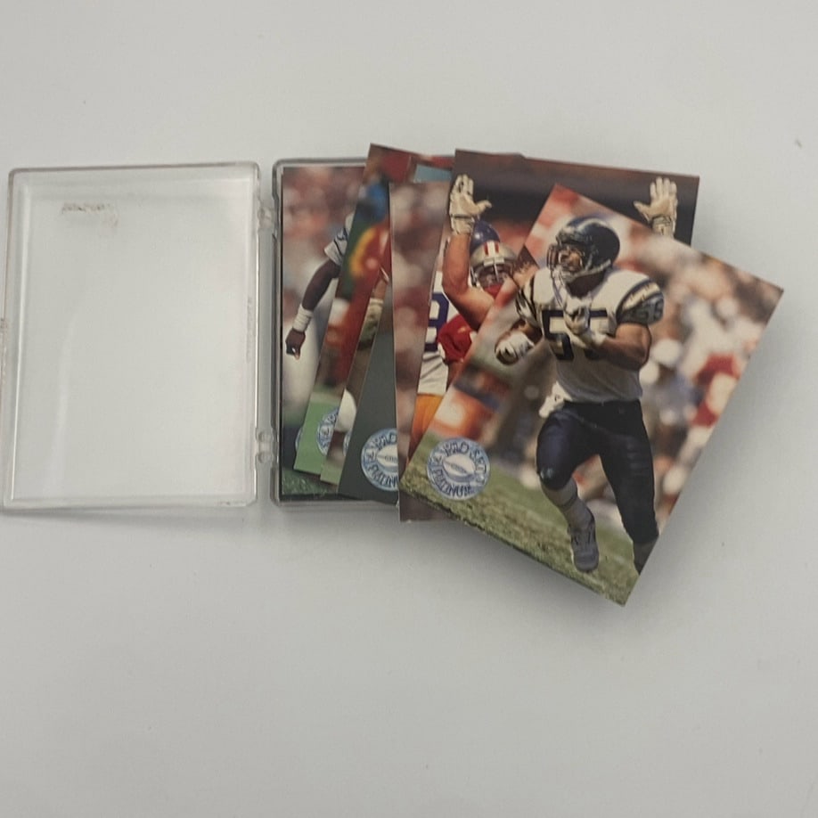 Junior Seau 1991 Pro Set Platinum #265: A collection of 1991 Pro Set Platinum football trading cards in a plastic case. The top card is #265 featuring Junior Seau of the San Diego Chargers in a white jersey. The set is characterized by