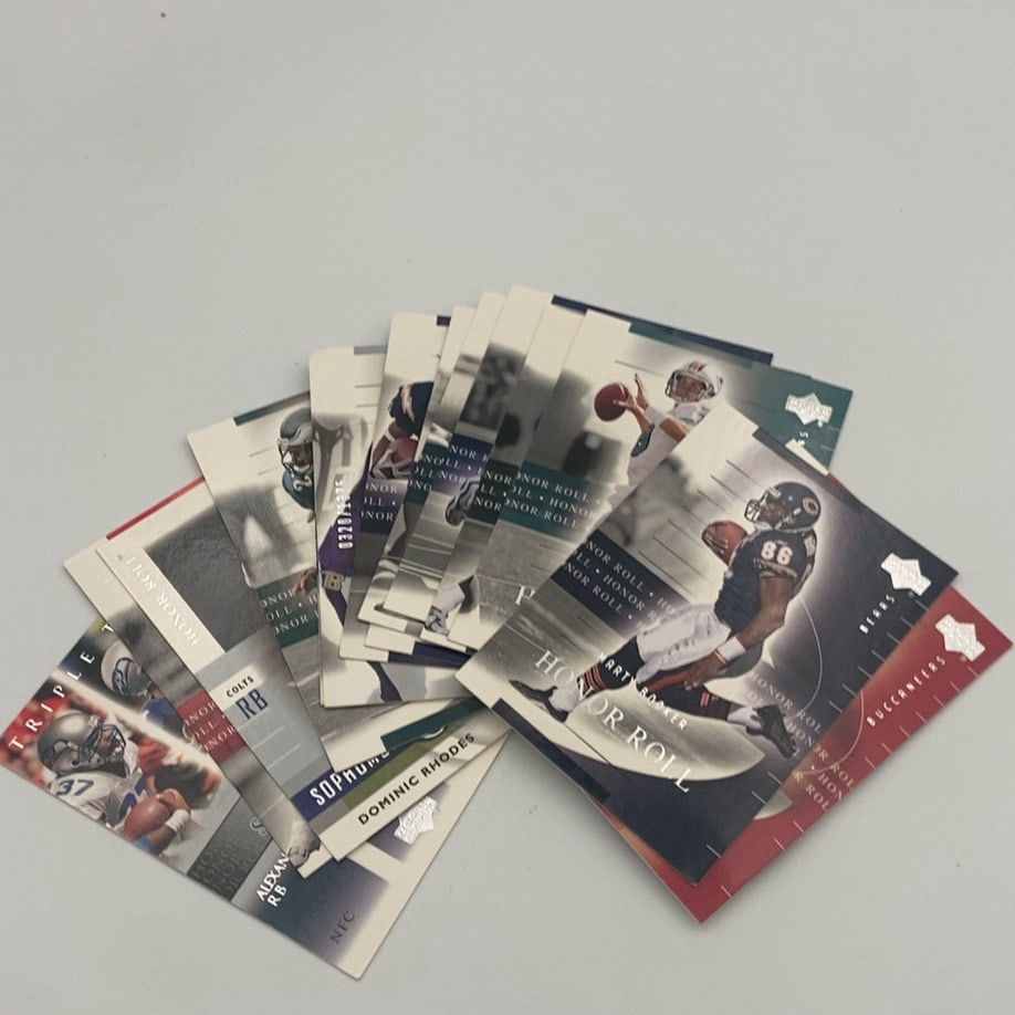 2002 Upper Deck Honor Roll Football Cards: A collection of 2002 Upper Deck Honor Roll football trading cards fanned out. Visible cards include Marty Booker of the Chicago Bears and Dominic Rhodes of the Indianapolis Colts. The cards feature th