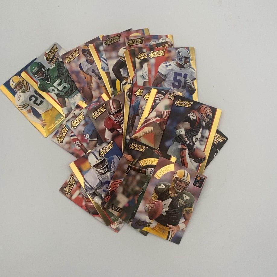 Action Packed Football Card Collection: A collection of 1992 Action Packed football cards featuring various NFL players, including Brett Favre in his Green Bay Packers uniform. The cards are known for their signature embossed design and gol