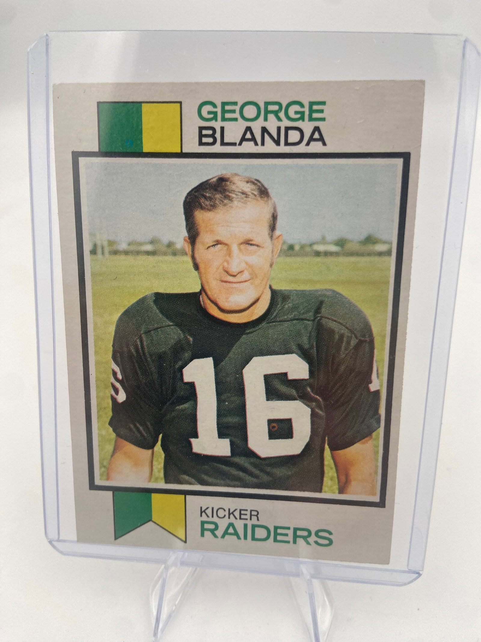 1972 Topps George Blanda Football Card: This is a 1972 Topps football card featuring George Blanda of the Oakland Raiders. The card is encased in a protective plastic top loader and shows the player wearing his iconic number 16 jersey.