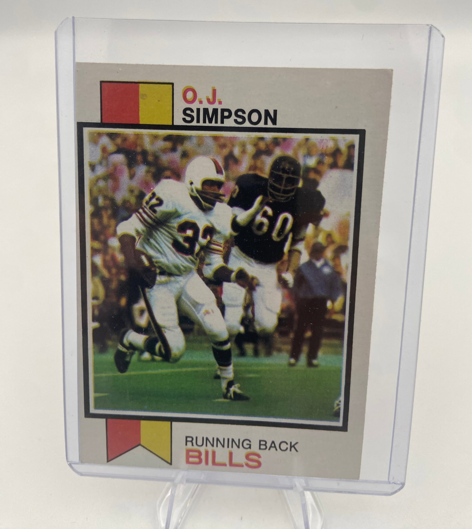 1973 Topps OJ Simpson Buffalo Bills Football Card: This is a 1973 Topps football card featuring NFL Hall of Fame running back O.J. Simpson of the Buffalo Bills. The card is encased in a rigid plastic toploader for protection. It displays classic 1973