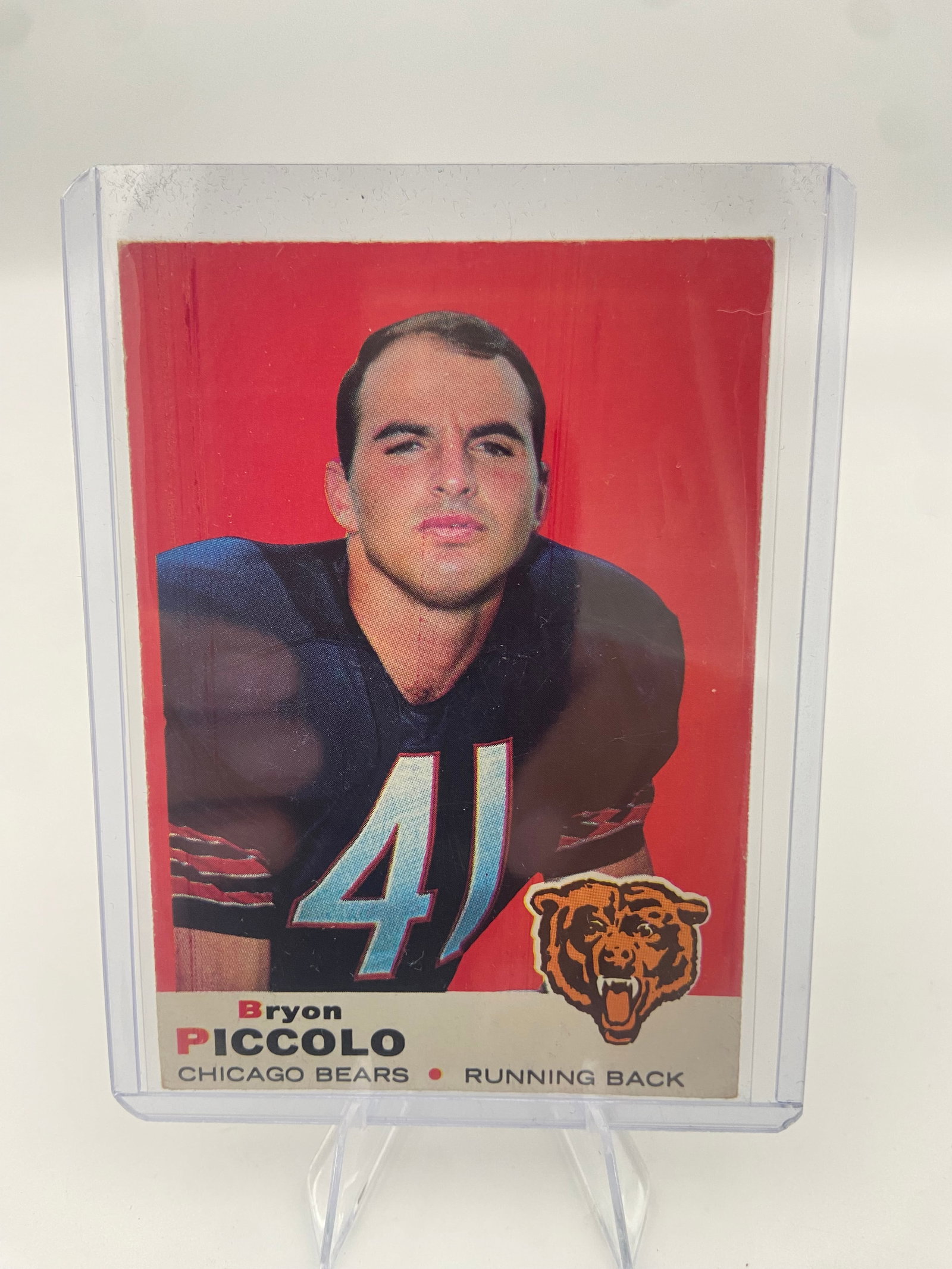 1970 Topps Brian Piccolo Chicago Bears Football Card: This is a 1970 Topps football card featuring Chicago Bears running back Brian Piccolo. The card displays his portrait along with the team logo and his name printed on the right side.