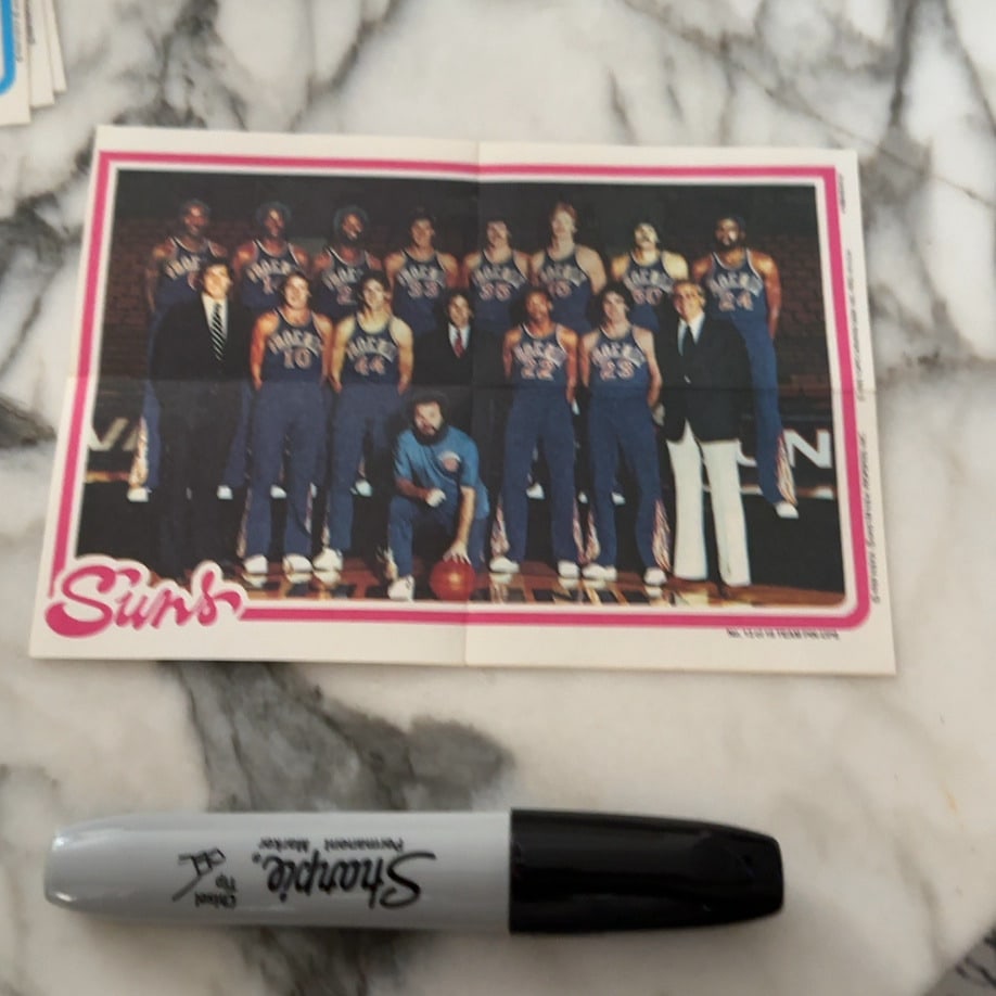 1970s Phoenix Suns Team Photo Poster: a vintage fold-out team poster featuring the Phoenix Suns basketball roster from the 1970s. The item shows the team in uniform on the court, consistent with NBA promotional materials from that era.