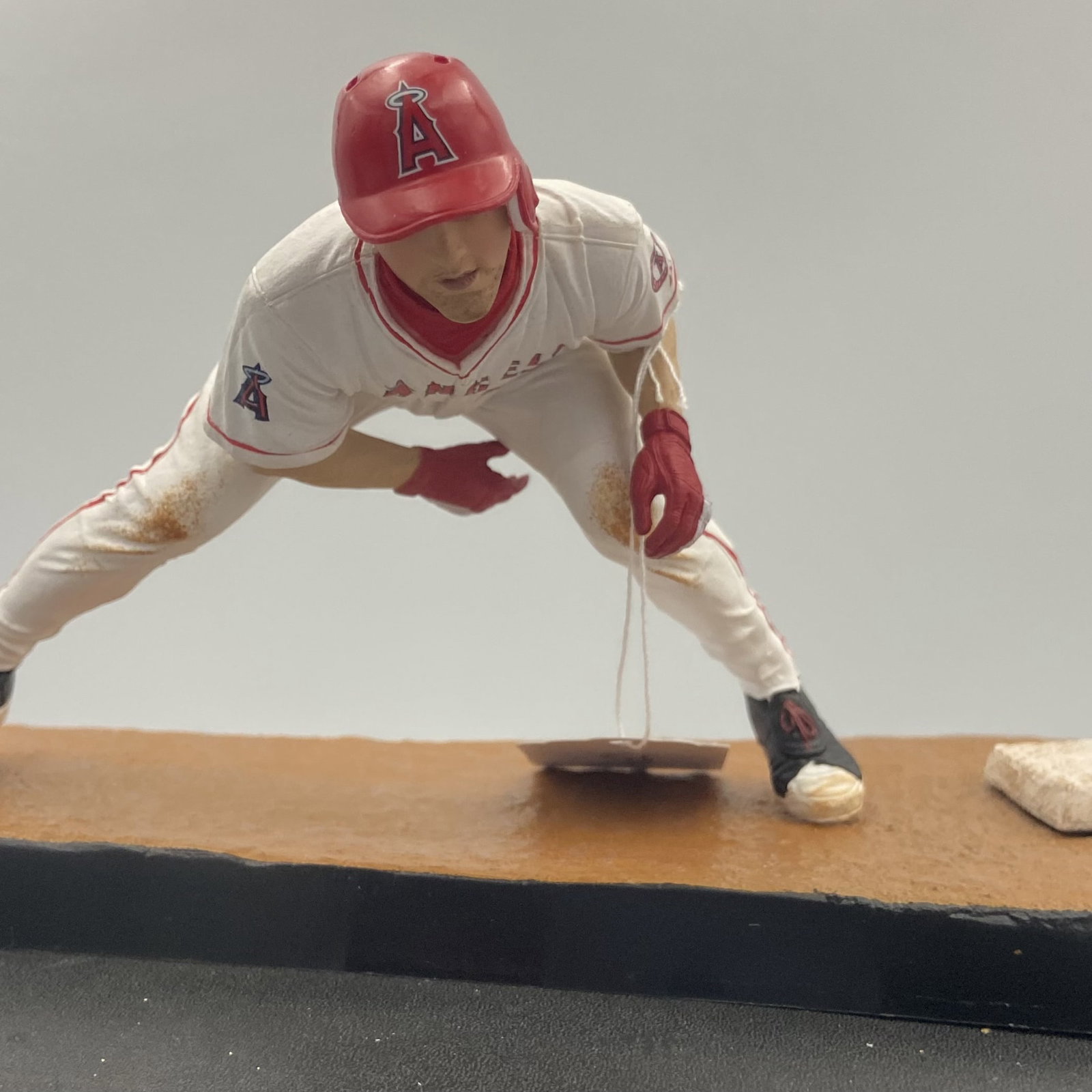 Mike Trout Angels Sports Figure: sports figurine depicting MLB star Mike Trout of the Angels. The player is shown in a dynamic batting or base-running posture wearing his home white uniform with number 27. It features detailed
