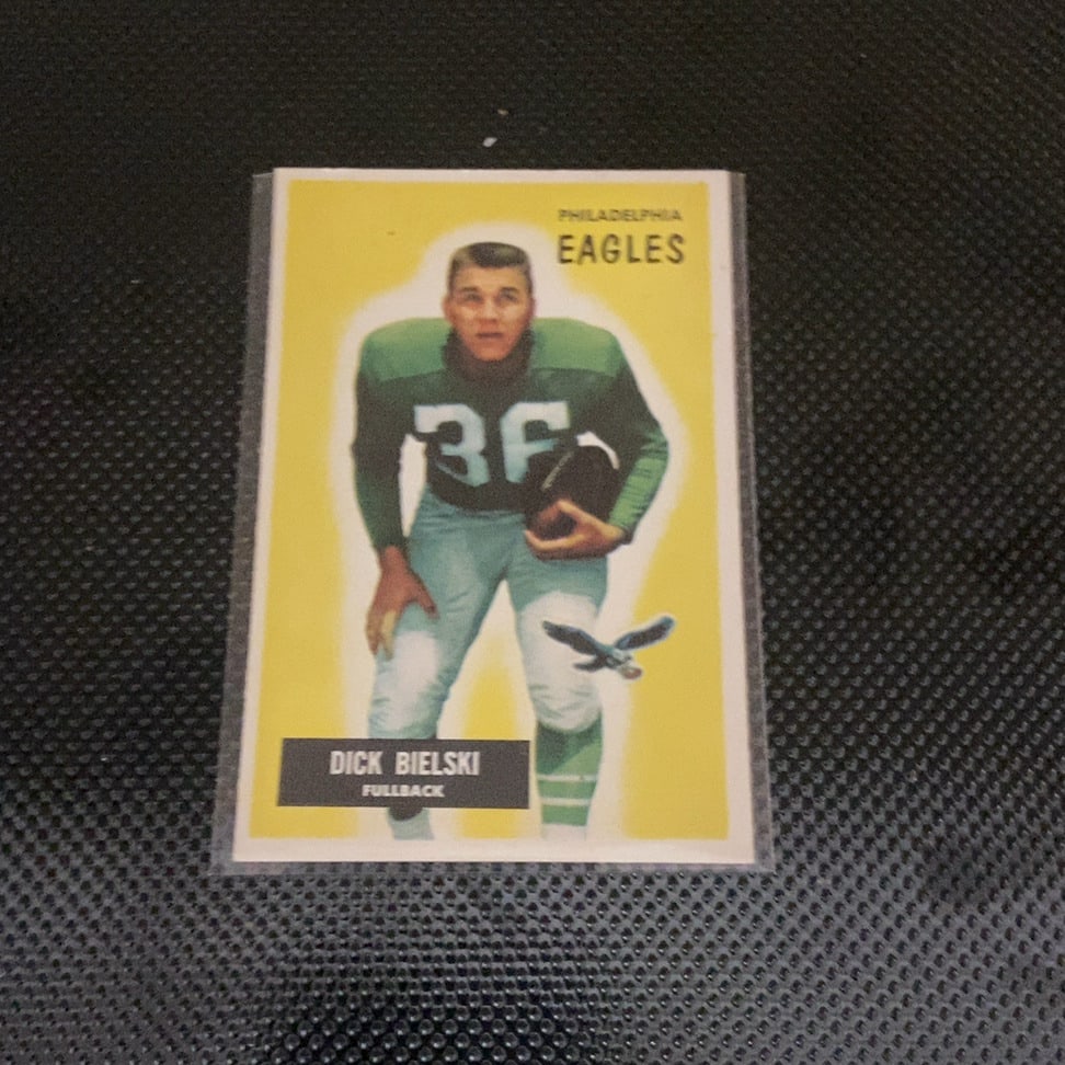 1960 Topps Dick Bielski Philadelphia Eagles: This is a 1960 Topps football card featuring Philadelphia Eagles fullback Dick Bielski. The card is enclosed in a protective plastic sleeve and depicts the player in his green team uniform against a