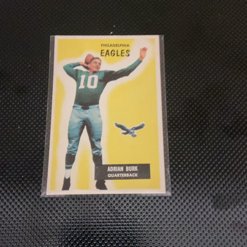 1955 Bowman Adrian Burk Philadelphia Eagles Card: This is a 1955 Bowman football card featuring Philadelphia Eagles quarterback Adrian Burk, numbered 10. The card showcases a distinct yellow background and highlights Burk in his team uniform. The