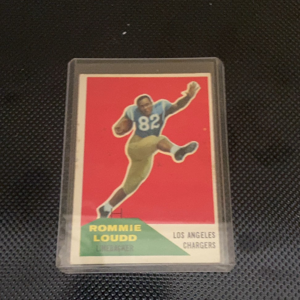 1960 Fleer Rommie Loudd Football Card: This is a 1960 Fleer football card featuring Rommie Loudd, a linebacker for the Los Angeles Chargers. The card displays a dynamic action shot against a bold red background and is preserved in a