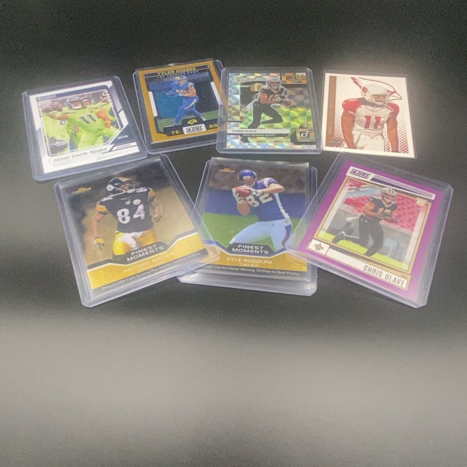 Assorted Football Trading Cards Lot: This lot contains an assortment of NFL football trading cards, including players such as Jaxon Smith-Njigba, Tyler Higbee, Chris Olave, Antonio Brown, and Kyle Rudolph. The cards are from various bran