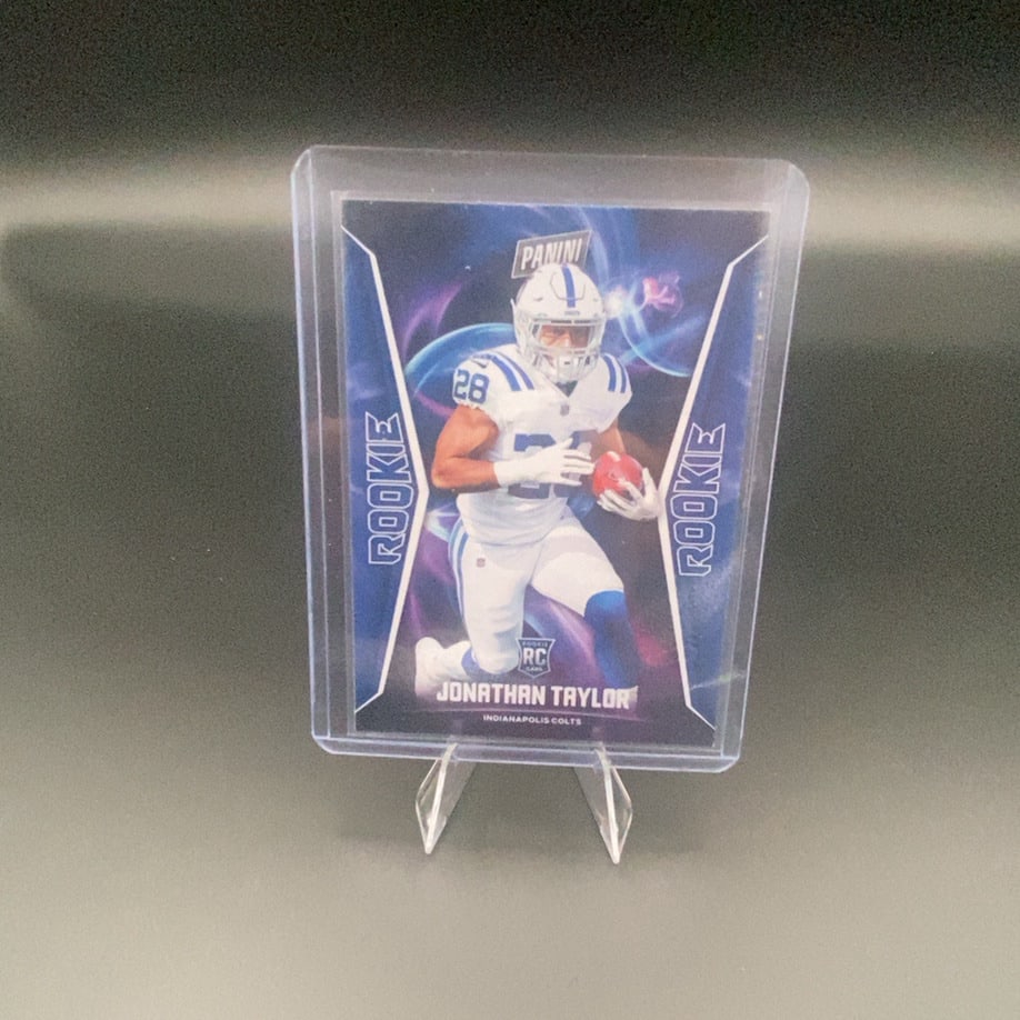2020 Panini Jonathan Taylor: This is a 2020 Panini rookie trading card featuring Indianapolis Colts running back Jonathan Taylor. The card displays a dynamic graphic design and prominently labels him as a rookie.