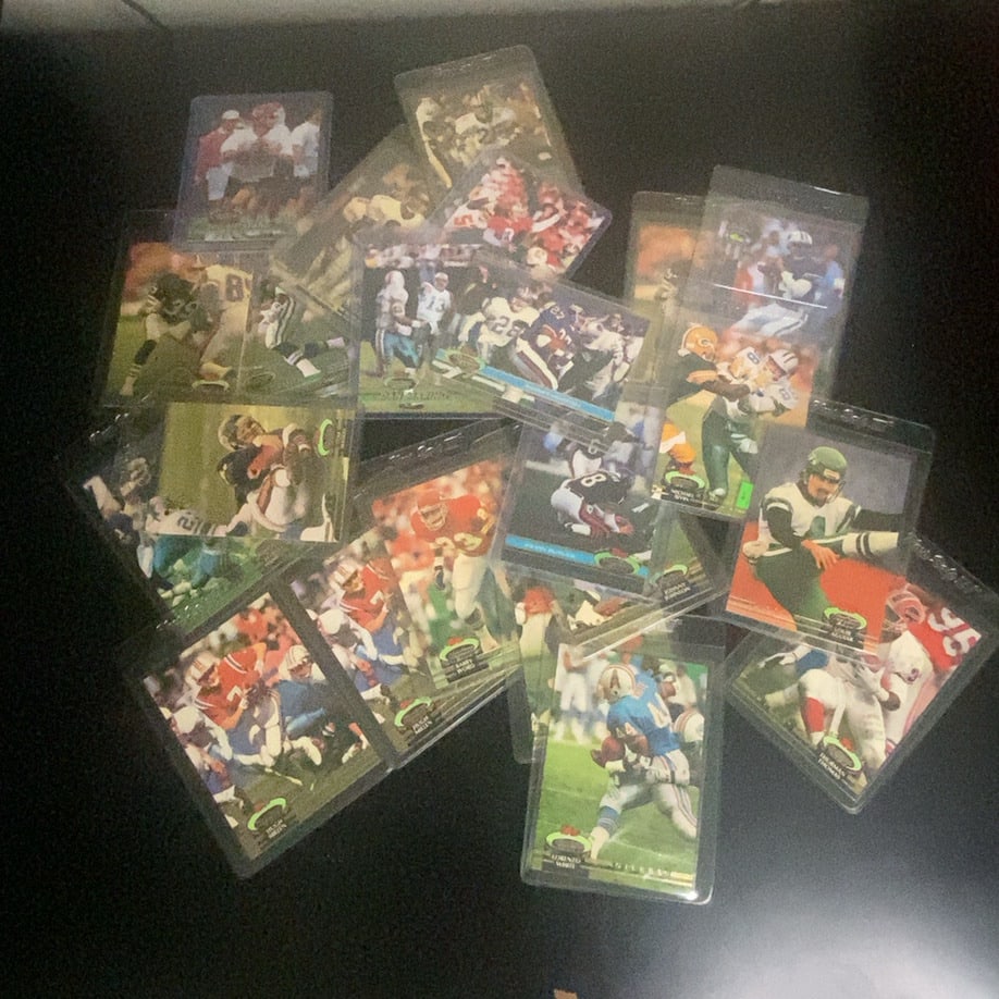 1992 Stadium Club Football Card Lot: This is a collection of various 1992 Stadium Club football cards enclosed in protective plastic sleeves. The cards feature various players in action shots, identifiable by the distinctive black