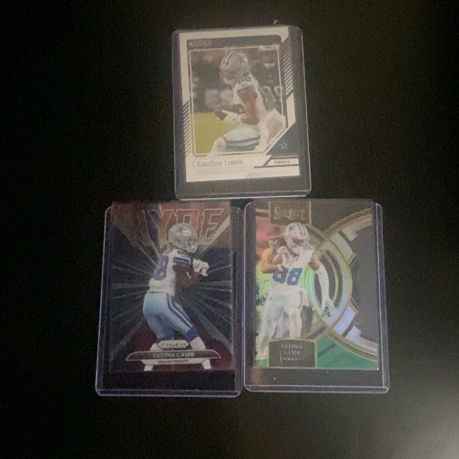 2020 Panini CeeDee Lamb Trading Card Collection: This image features three distinct trading cards of Dallas Cowboys wide receiver CeeDee Lamb. The collection includes cards from Panini Score, Panini Prizm, and Panini Select brands. These cards