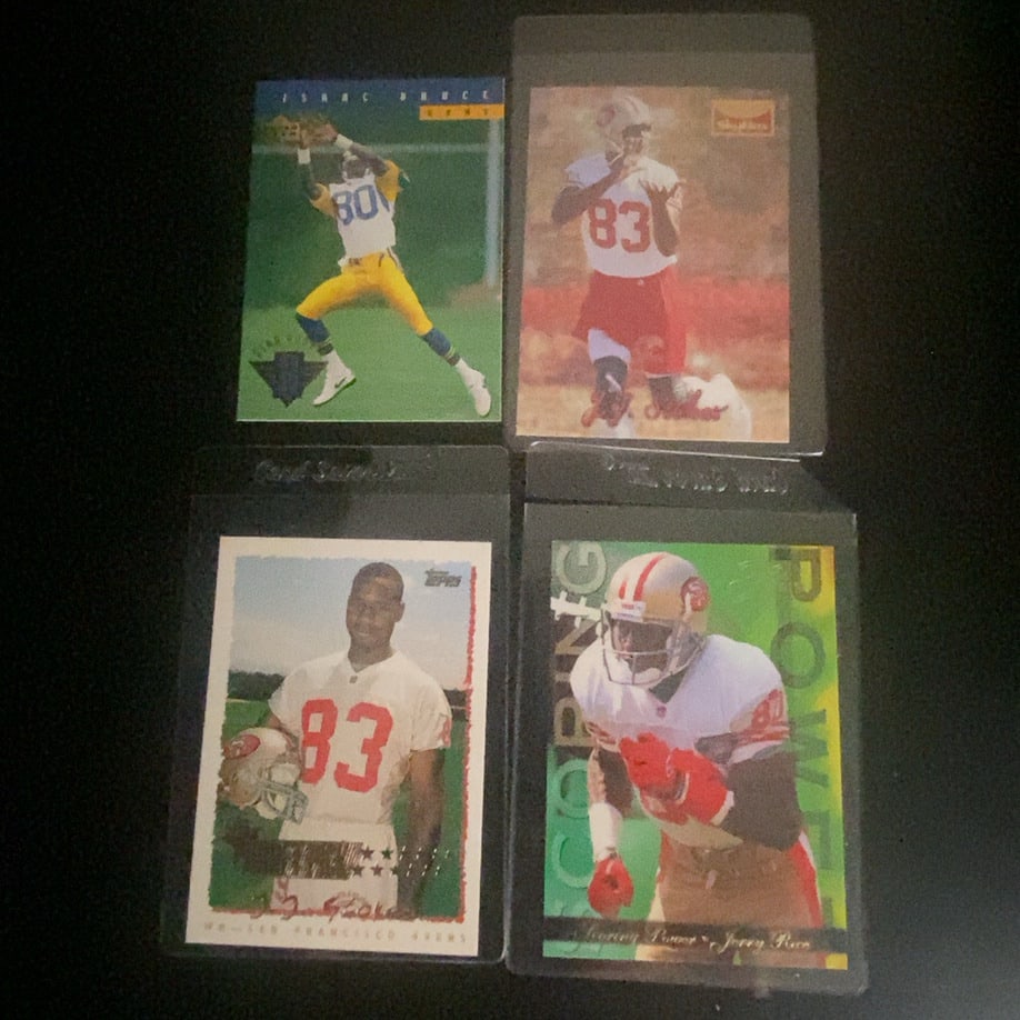 1990s Assorted Football Trading Cards: This lot contains four professional football trading cards featuring players like Isaac Bruce and Jerry Rice. The cards include brands such as Topps and Skybox from the 1990s era. These collectible ca