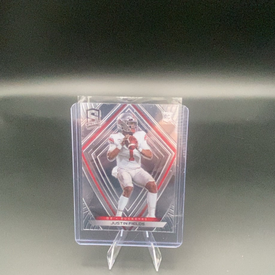 2021 Panini Spectra Justin Fields: This is a 2021 Panini Spectra football trading card featuring Justin Fields, the quarterback for the Ohio State Buckeyes. The card is labeled with the 'RC' rookie logo and showcases the distinctive