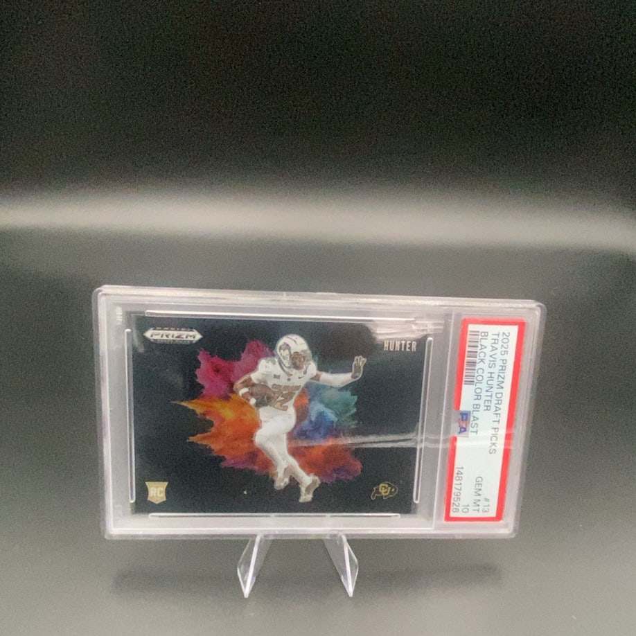 2025 Panini Prizm Draft Picks Travis Hunter: This is a 2025 Panini Prizm Draft Picks trading card featuring Travis Hunter. The card is a PSA-graded Black Color Blast parallel, which is a rare insert. It is professionally encapsulated in a