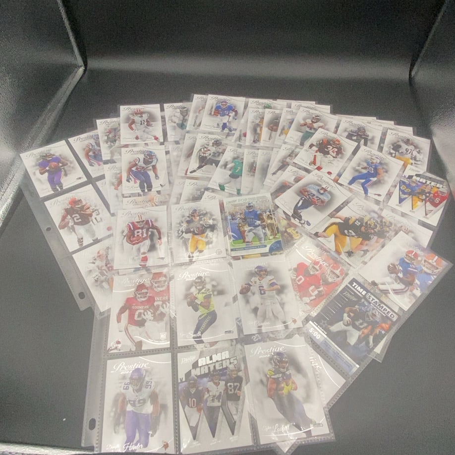 2023 Panini Prestige Football Trading Card Lot: This is a large collection of 2023 Panini Prestige football trading cards housed in a protective plastic binder sheet. The collection features various NFL players, including rookies and notable stars 