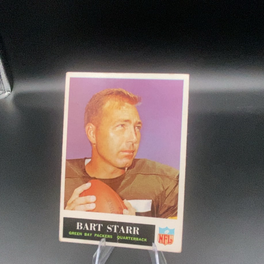 Bart Starr Green Bay Packers: This is a vintage trading card featuring Green Bay Packers quarterback Bart Starr. The card highlights his name and team affiliation prominently on the front along with an NFL logo.