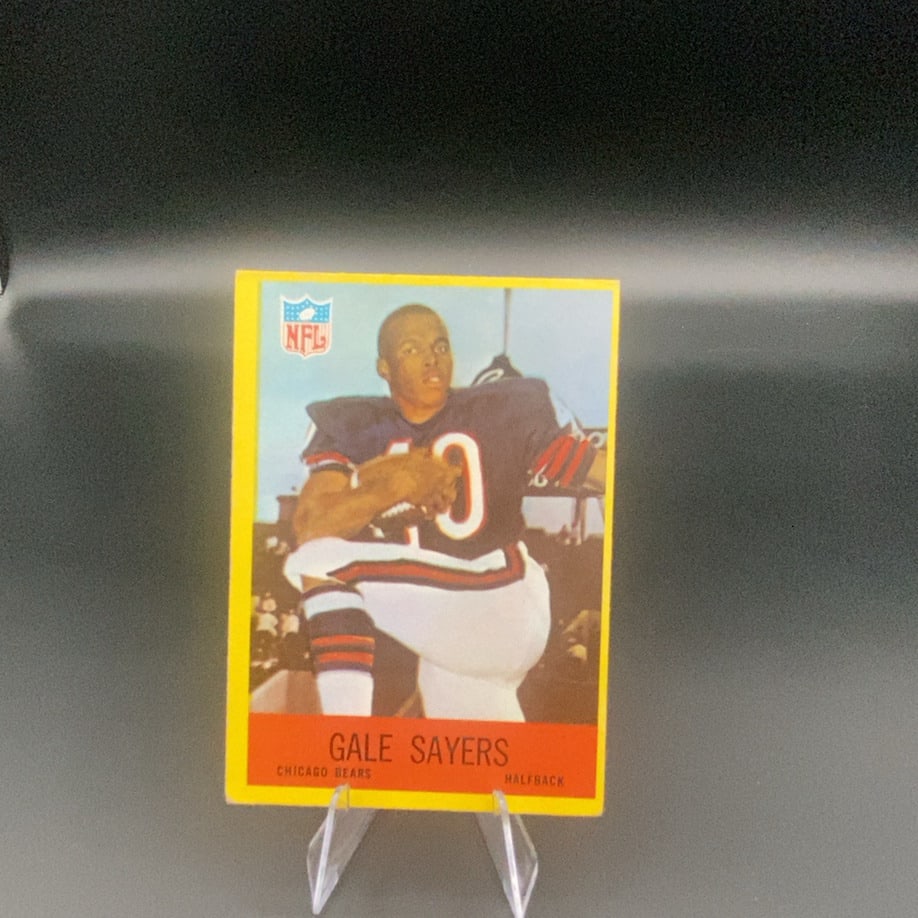 Vintage Gale Sayers Chicago Bears Sports Card: This is a vintage sports card featuring Gale Sayers, a halfback for the Chicago Bears. The card prominently displays the NFL logo and identifies the player's team and position at the bottom.
