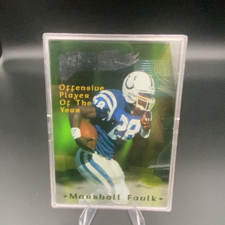 Marshall Faulk Indianapolis Colts Offensive Player Year Card: This is a collectible trading card featuring NFL player Marshall Faulk in his Indianapolis Colts uniform. The front of the card highlights him as an 'Offensive Player Of The Year' award recipient.